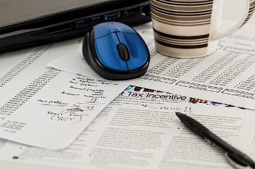 tax forms, laptop, mouse, coffee cup